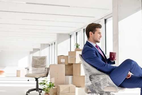 גבר יושב במשרד ארוז ומוכן להעברה