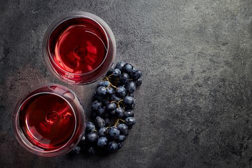 יין אדום לצד ענבים אדומים