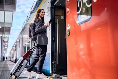 אישה צעירה עם כבודה עולה על רכבת לנתבג