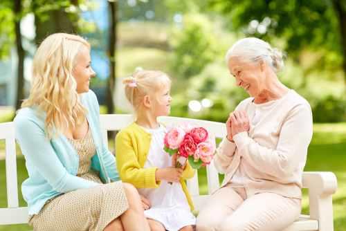 אמא ובת מביאות לסבתא פרחים לכבוד היציאה לגמלאות