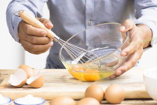 גבר מקציף ביצים להכנת עוגת נוטלה ללא גלוטן